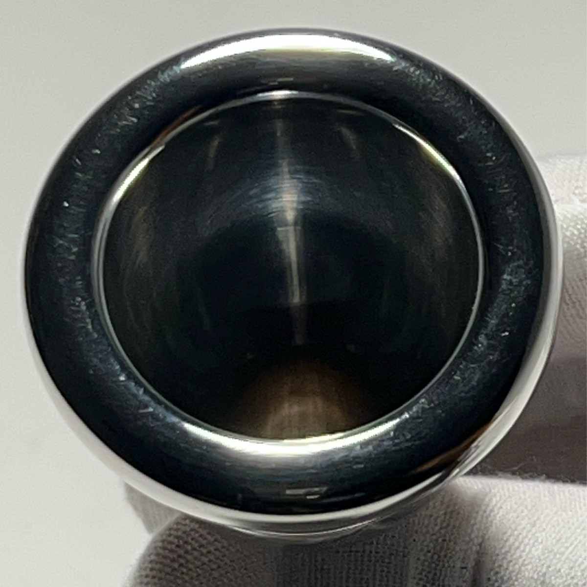 Silver Robert Tucci Tuba Mouthpiece held up to camera so you can see the rim and inside of the cup well.