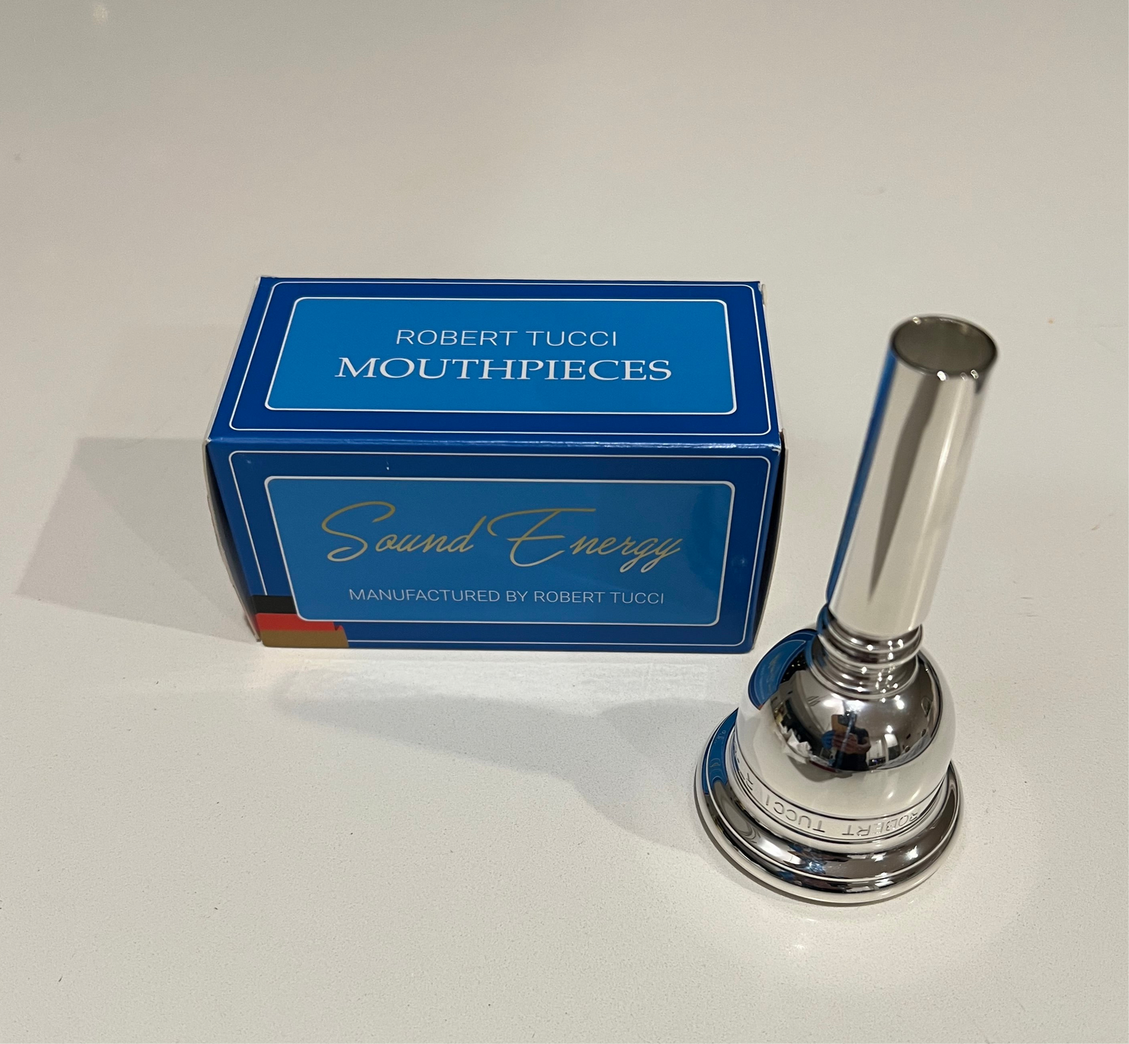 Silver tuba mouthpiece with Robert Tucci mouthpieces box on a white background
