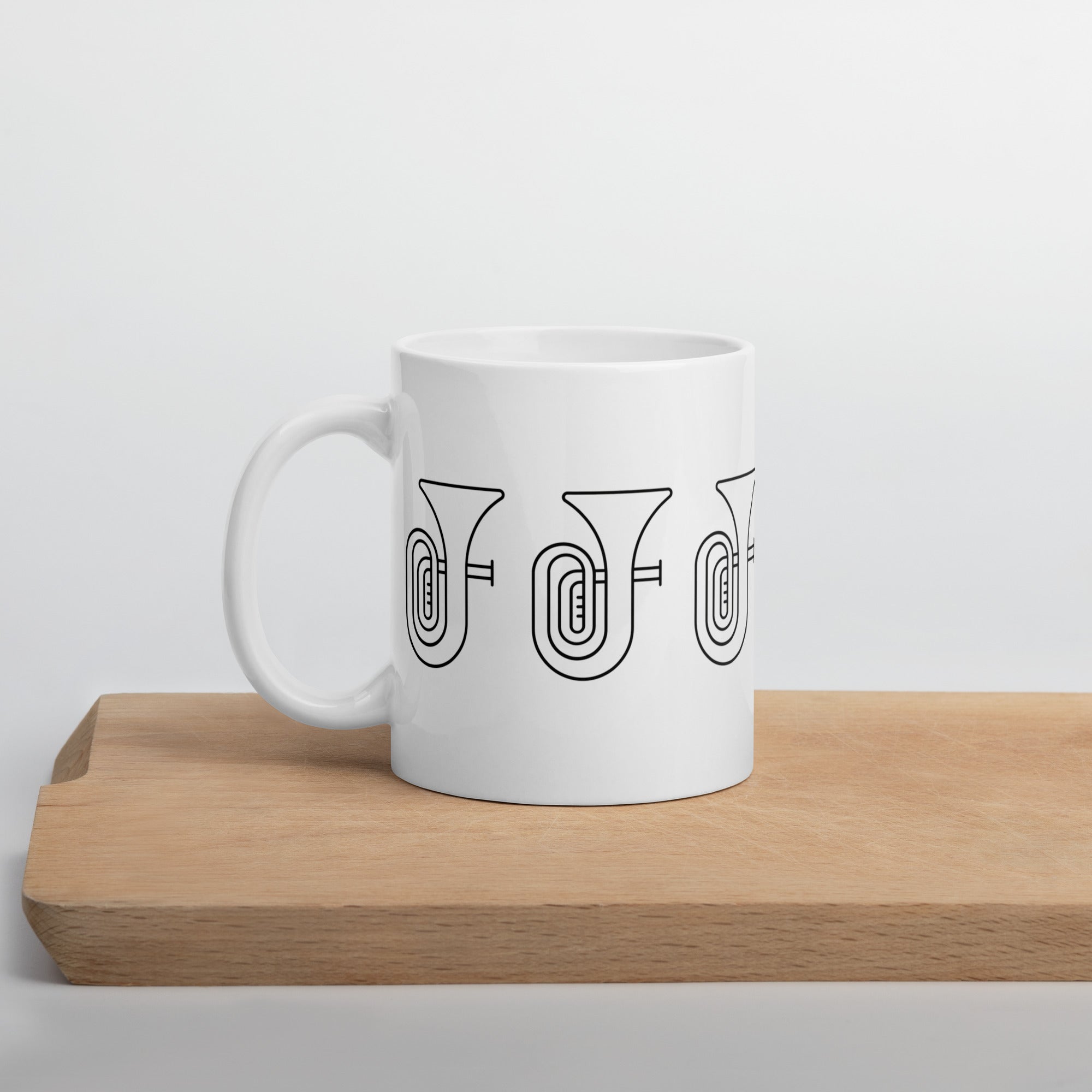 White mug with musical instrument design on a wooden surface
